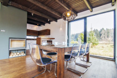 Interiér výberom materiálu i farebnosťou korešponduje s exteriérom. Prevládajú odtiene prírodného dreva doplnené antracitovým náterom kovových prvkov a kozubového telesa. Väčšinu vybavenia tvoria originály vyrobené podľa návrhu architekta, napríklad jedálenský stôl zo stropných trámov