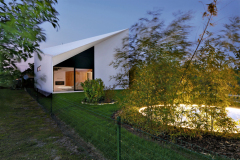 Do lichobežníkového hlavného priečelia zapustili presklenú stenu, vymedzenú skosenými plochami. Pre rodinný dom ide o neobvyklú architektonickú kompozíciu