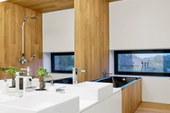 Základná kombinácia bielych plôch, prírodného dreva a čiernych prvkov sa opakuje aj v ostatných priestoroch vrátane kúpeľní