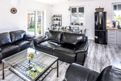 Hlavnej obytnej časti dominuje masívna kožená sedacia súprava, doplnená oceľovým nábytkom IKEA, ktorý naopak priestor interiéru odľahčuje