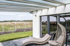 Priestranná vonkajšia terasa je zastrešená pergolou so špeciálnym sklom, ktoré je priesvitné, ale neprepustí ostré slnečné lúče a žiaru