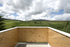 Balkón z masívnych drevených panelov, prístupný z rodičovskej spálne, poskytuje nerušený výhľad na okolité hrebene hôr