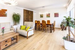 Hlavná obytná miestnosť domu s jedálenským stolom a sedacou súpravou. Posuvné dvere slúžia na praktické oddelenie kuchyne od zvyšku hlavného obytného priestoru