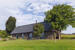 Novostavba vychádzajúca z archetypu pôvodných vonkajších stavieb nahradila chalúpku z lepenej hliny. Prevzala jej tvaroslovie vrátane sklonu strechy, rozmery a detaily však zodpovedajú súčasným požiadavkám