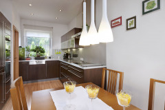 Kuchynskú časť jasne vymedzuje čokoládový odtieň kuchynskej linky