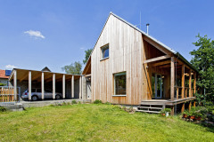 Na západnej strane, priamo pri vjazde na pozemok stojí kryté automobilové státie so skladom, z ktorého možno suchou nohou prejsť až do závetria domu