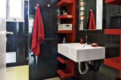 Vybavenie kúpeľne sa nesie v kombinácii čiernej a červenej farby, dlážku tvoria veľkoformátové keramické dlaždice