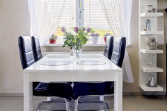 Jedálenský stôl je umiestnený pod oknom. Ako vidno, žalúzia nepustí do domu viac svetla, než je žiaduce