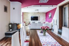 V interiéri majitelia domu skombinovali výrazné farby s prírodnými materiálmi a ich imitáciami, na dlážky zvolili laminát s dezénom dreva, obklad čelnej steny v obývačke napodobňuje lomový kameň